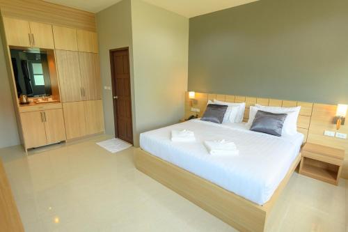 a bedroom with a large white bed with two pillows at Avarin Resort in Pak Chong