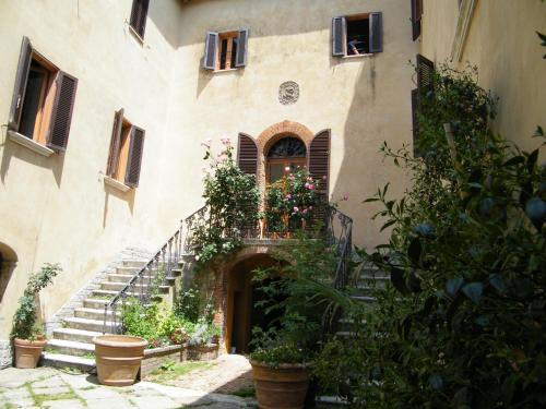 a building with stairs and flowers in front of it at B&B Il Glicine in Montefollonico