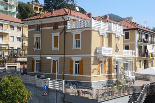 un grand bâtiment jaune avec un balcon dans une rue dans l'établissement Hotel Ines, à Varazze