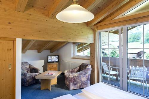 a room with a bed and a table and chairs at Ferienhotel Alpenhof in Aurach bei Kitzbuhel