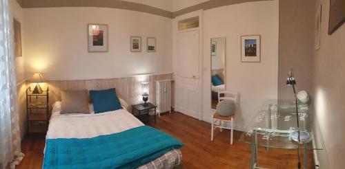 1 dormitorio con cama y mesa de cristal en L Hôte Rutène, en Rodez
