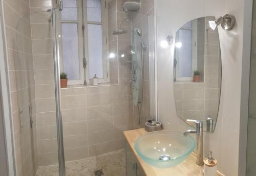 een badkamer met een glazen wastafel en een douche bij L Hôte Rutène in Rodez