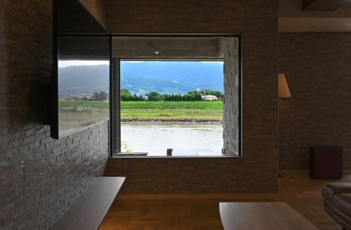 a room with a window with a view of a river at 原鶴の舞 in Asakura