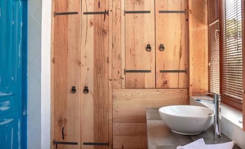a bathroom with a wooden door and a white bowl at Ethno Sazano Hotel in Sazano