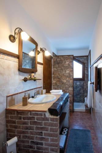 a bathroom with a sink and a brick wall at Vv El Lagar de Tunte Fibra Internet in San Bartolomé