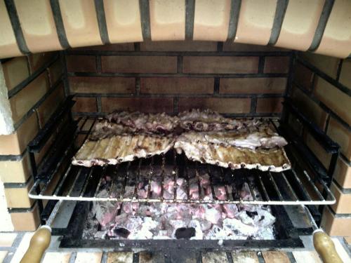 un groupe de poulets cuisinant sur un grill dans l'établissement Retiro do Mestre, à Mondim de Basto