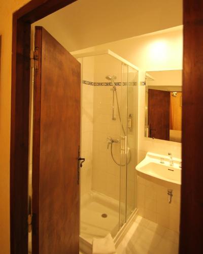 une salle de bain avec douche et lavabo dans l'établissement Hostellerie Le Beffroi, à Vaison-la-Romaine