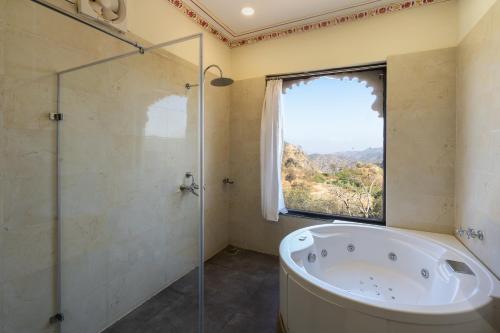 y baño con bañera y ducha acristalada. en The Kumbha Bagh en Kumbhalgarh