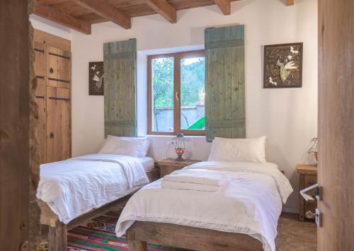 2 camas en una habitación con ventana en Ethno Sazano Hotel en Sazano