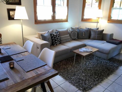 uma sala de estar com um sofá e uma mesa em Penthouse Apartment - Sez Ner em Obersaxen