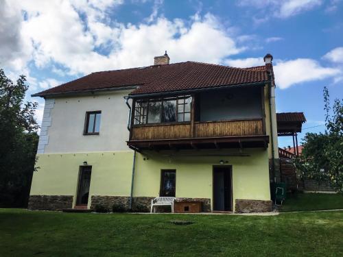 a white house with a deck on top of it at Apartmán v Zahradní in Prachatice