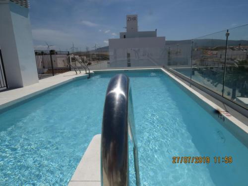 a swimming pool on the roof of a building at Apartamentos Cachón in Zahara de los Atunes