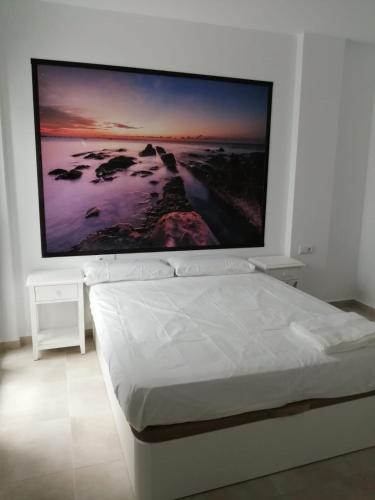 a bedroom with a large flat screen tv on the wall at Apartamentos Cachón in Zahara de los Atunes