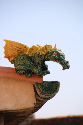 a statue of a dragon sitting on a ledge at Hostel Le Diablotin in Saint-Jean-de-Fos