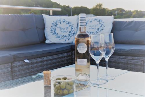 a bottle of wine and two wine glasses on a table at Floating vacationhome Tenerife in Maastricht