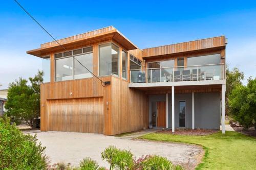 una gran casa de madera con muchas ventanas en Aires Coastal Beach House Luxury with Ocean Views, en Aireys Inlet