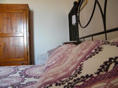 a bedroom with a bed and a wooden cabinet at B&B Il Glicine in Montefollonico