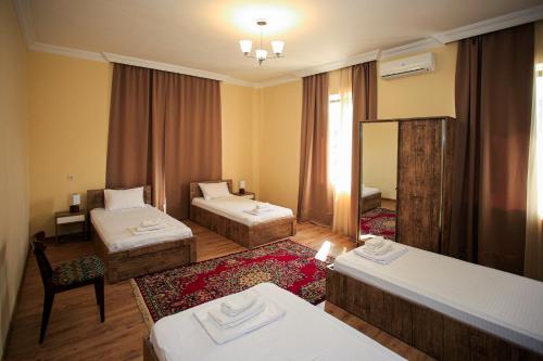 a hotel room with two beds and a mirror at Bucha`s Guest House & Wine Cellar in Tʼelavi