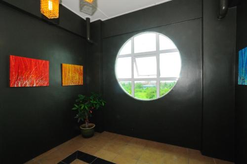 a room with a round window in a black wall at OYO 89908 Hotel Kensington in Sandakan