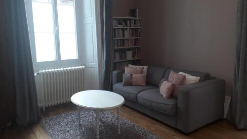 sala de estar con sofá y mesa en Les Pierres Bleues, en Bar-sur-Aube