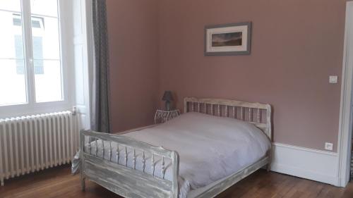 1 dormitorio con cama y ventana en Les Pierres Bleues, en Bar-sur-Aube