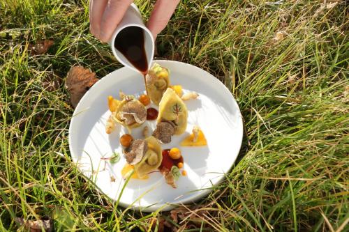 a plate of food with a person holding a spoon at Parkhotel Sole Paradiso in San Candido