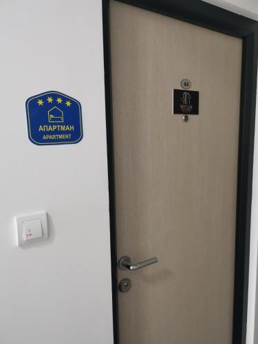 a door with a sign on it in a room at Sky lux apartman in Gornji Milanovac