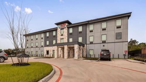 a large building with a truck parked in front of it at SureStay Plus Hotel by Best Western Humble in Humble