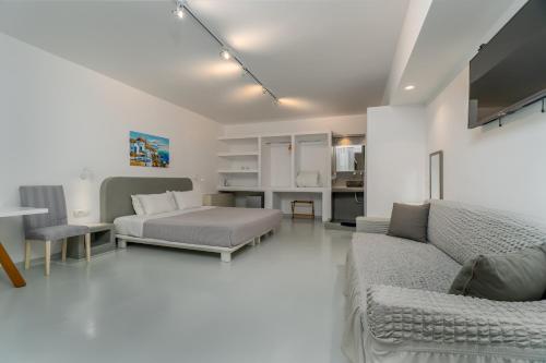 a living room with a couch and a bed at Central Fira Suites in Fira