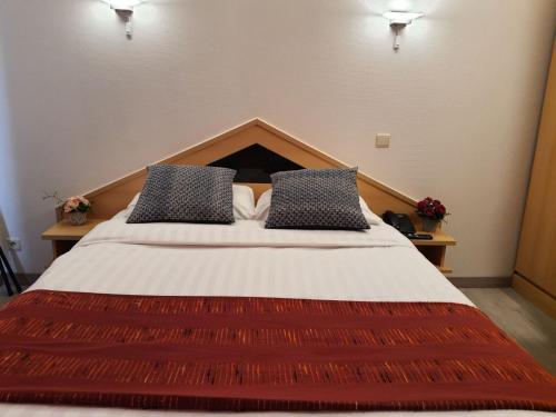 a bedroom with a large bed with two pillows at Hotel New Flanders in Sint-Niklaas