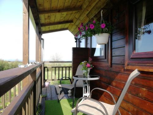 una veranda con tavolo e sedie su una casa di Carrowkeel Cabin a Sligo