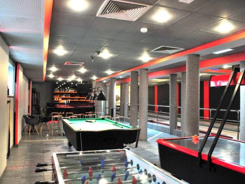 a billiard room with a pool table and a bar at ibis Styles Warszawa West in Mory