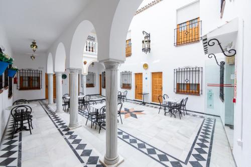 a room with chairs and tables in a building at Hotel Los Omeyas in Córdoba