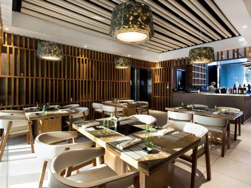 a restaurant with tables and chairs and a bar at Fairmont Bab Al Bahr in Abu Dhabi