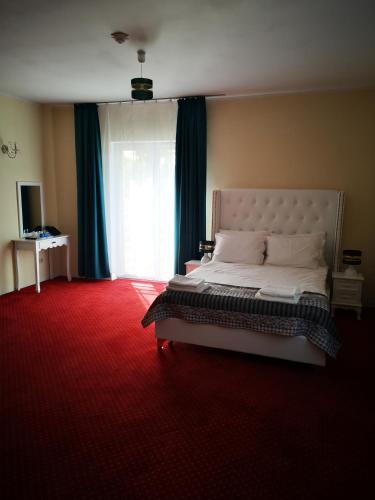 a bedroom with a large bed with a red carpet at Hotel i Restauracja Admirał in Legnica