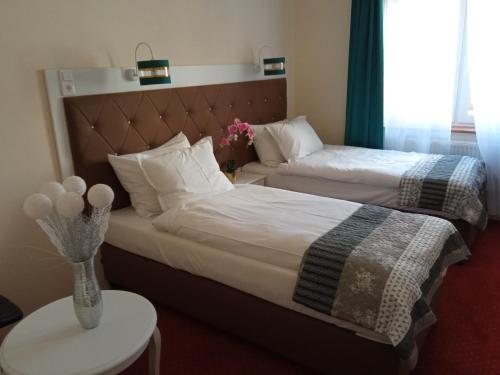 a hotel room with two beds and a table at Hotel i Restauracja Admirał in Legnica