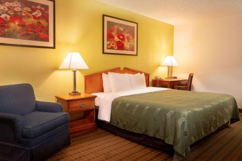 a hotel room with a bed and a chair at Quality Inn at Arlington Highlands in Arlington