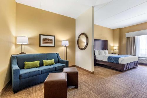 a hotel room with a bed and a couch at Comfort Suites Frisco in Frisco