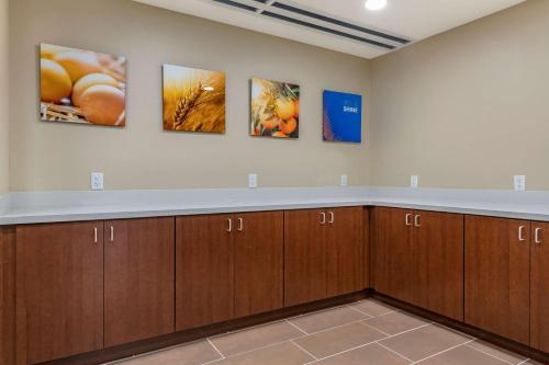 a room with wooden cabinets and paintings on the wall at Comfort Suites Daytona Beach-Speedway in Daytona Beach