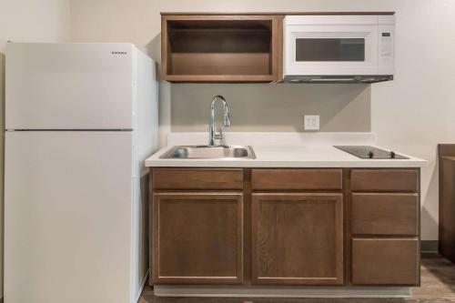 a kitchen with a white refrigerator and a sink at WoodSpring Suites Lake Jackson in Lake Jackson