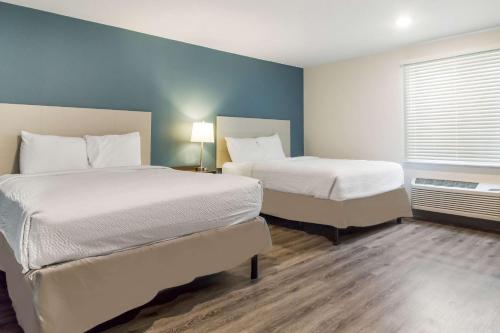 a hotel room with two beds and a window at WoodSpring Suites Lake Jackson in Lake Jackson
