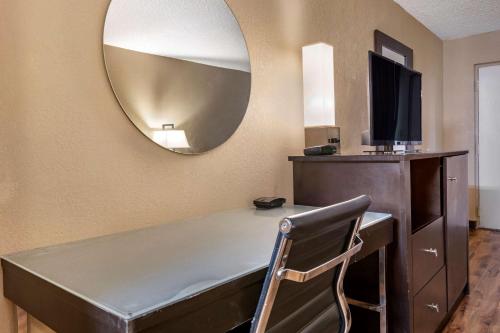 a room with a desk with a mirror and a chair at Econo Lodge Sebring in Avon Park