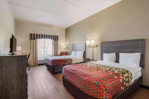 a hotel room with two beds and a flat screen tv at Econo Lodge Inn & Suites in Marianna