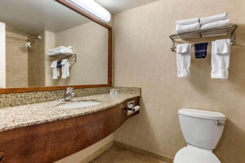 a bathroom with a sink and a mirror and a toilet at Big Horn Resort, Ascend Hotel Collection in Billings