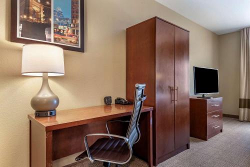 a room with a desk with a lamp and a chair at Comfort Suites Mason near Kings Island in Mason