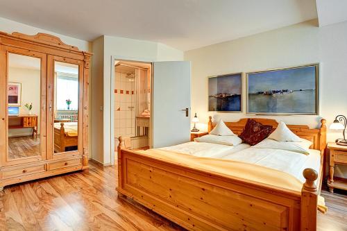 Un dormitorio con una gran cama de madera. en Stadthotel Detmold, en Detmold