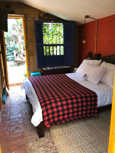 a bedroom with a bed with a checkered blanket at Mi Casa es tu Casa Inn in Chiquinquirá