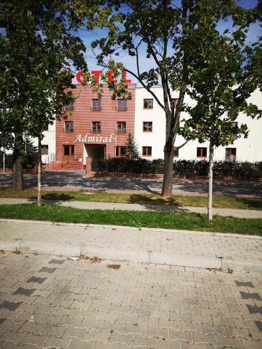 a building with a sign on it in front of trees at Hotel i Restauracja Admirał in Legnica