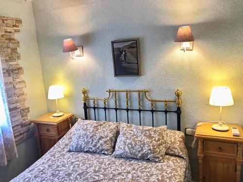 ein Schlafzimmer mit einem Bett mit zwei Nachttischen und zwei Lampen in der Unterkunft Finca Bellas Vistas in Padul