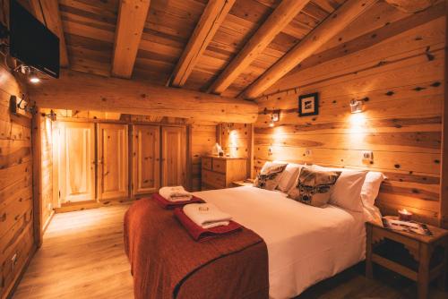 a bedroom with a bed in a log cabin at Chalet Panoramique by Chalet Chardons in Tignes